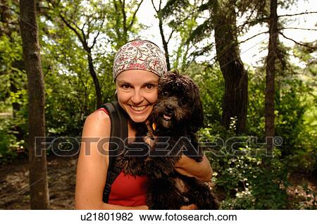 Stock Image - Woman hiker with dog in woods, Regina, Saskatchewan. Fotosearch