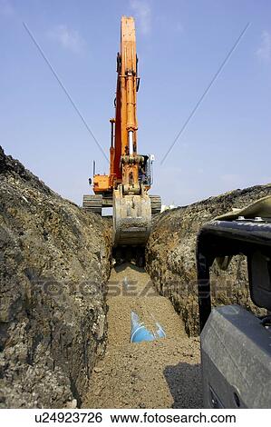 Excavator filling in section of drainage pipe with dirt; Canada, Ontario, Hamilton (Composting Facility) View Large Photo Image Stock Photograph - Excavator filling in section of drainage pipe with dirt; Canada, Ontario, Hamilton (Composting Facility). Fotosearch