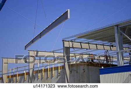 Stock Image - Steel girder being lifted onto roof of building; Canada, Ontario, Hamilton (Composting Facility). Fotosearch