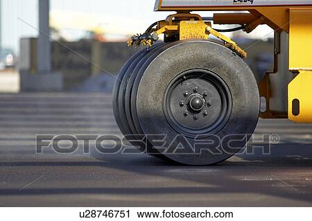 Stock Image - Wheels of paving roller on new asphalt; Canada, Ontario, Hamilton (Composting Facility). Fotosearch