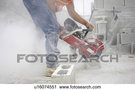 Worker cutting a cinder block with a circular saw; Canada, Ontario, Hamilton (Composting Facility) View Large Photo Image Stock Image - Worker cutting a cinder block with a circular saw; Canada, Ontario, Hamilton (Composting Facility). Fotosearch
