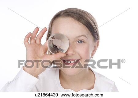 Stock Photo - 9 year old girl with the glass globe in front of her face. Fotosearch
