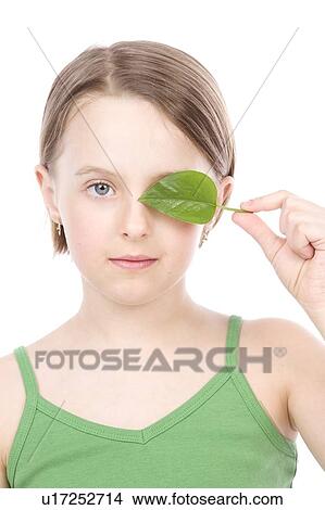 9 year old girl with the green leaf in front of her face View Large Photo Image Picture - 9 year old girl with the green leaf in front of her face. Fotosearch