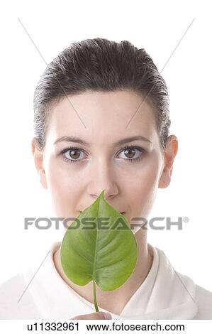 face of a young woman with a leaf held in front of mouth View Large Photo Image Stock Image - face of a young woman with a leaf held in front of mouth. Fotosearch