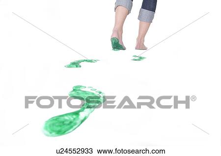 Stock Image - Feet walking leaving a set of green footprints. Fotosearch