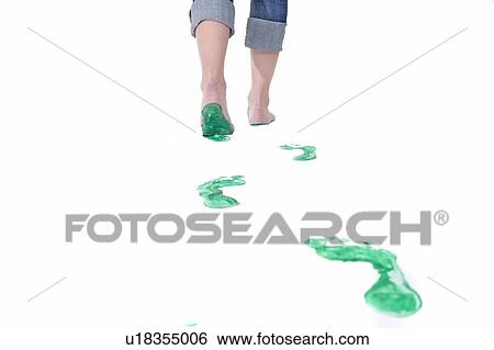 Stock Photograph - Feet walking leaving a set of green footprints. Fotosearch