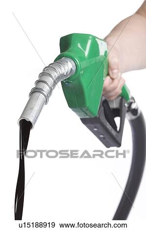 Stock Photo - Hand holds gas nozzle with stream of oil flowing out. Fotosearch