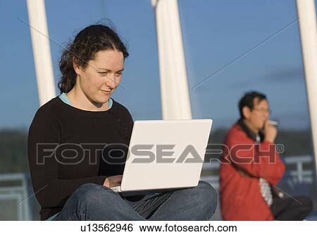Stock Photograph - A woman works on her laptop while commuting between Vancouver and Victoria on a BC Ferry. Fotosearch