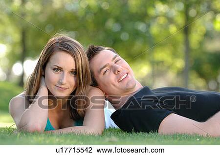 Stock Image - Boy and girl teenagers in grass at park, Regina, Saskatchewan. Fotosearch