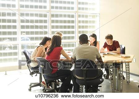 Stock Photograph - Group of students seated around table in front of solar panelled windows, Winnipeg, Canada. Fotosearch