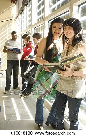 Stock Image - Groups of students casually talking, beside solar panelled windows, Winnipeg, Canada. Fotosearch