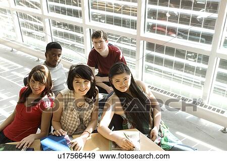 Stock Photo - High angle portrait of students seated around table in front of solar panelled windows, Winnipeg, Canada. Fotosearch
