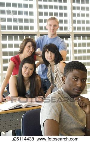 Stock Photo - Male student foreground, group of students in background, in front of solar panelled windows, Winnipeg, Canada.. Fotosearch