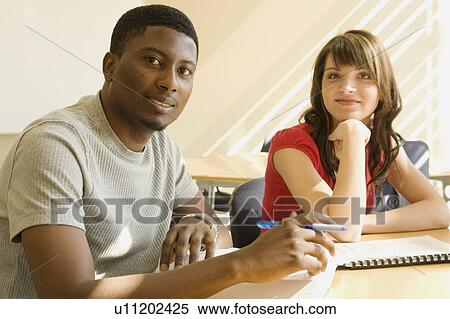 Stock Photography - Portrait of 2 students seated at table, Winnipeg, Canada. Fotosearch