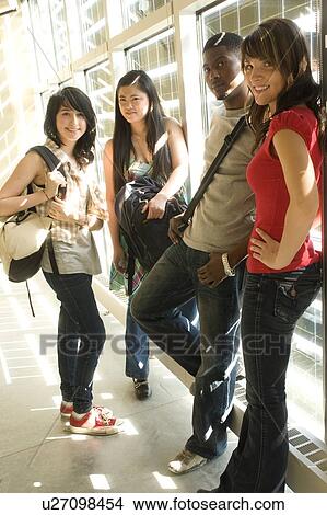 Picture - Portrait of four students standing beside solar panelled windows, Winnipeg, Canada. Fotosearch