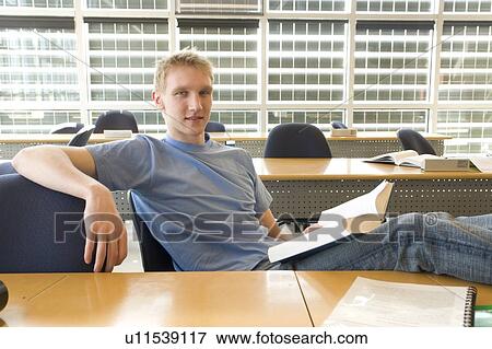 Stock Photo - Portrait of male student in front of solar panelled windows, Winnipeg, Canada.. Fotosearch