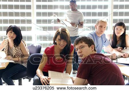Stock Photography - Portrait of students casually seated and standing by tables in front of solar panelled windows, Winnipeg, Canada.. Fotosearch