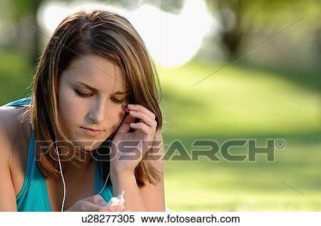 Stock Photography - Teenage girl in park w/ipod, Regina, Saskatchewan. Fotosearch
