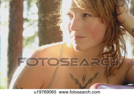 Stock Photography - Woman looking off, in a grove of trees, Riding Mountain National Park, Manitoba, Canada. Fotosearch