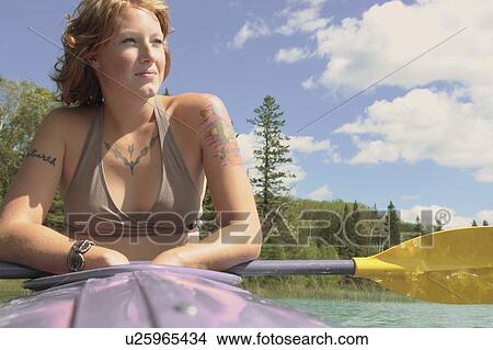 Woman rests paddle of kayak, Lake Katherine, Riding Mountain National Park, Manitoba, Canada View Large Photo Image Picture - Woman rests paddle of kayak, Lake Katherine, Riding Mountain National Park, Manitoba, Canada. Fotosearch