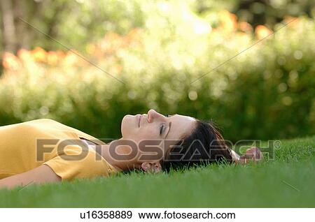 Young woman laying on grass, Regina, Saskatchewan View Large Photo Image Stock Photo - Young woman laying on grass, Regina, Saskatchewan. Fotosearch