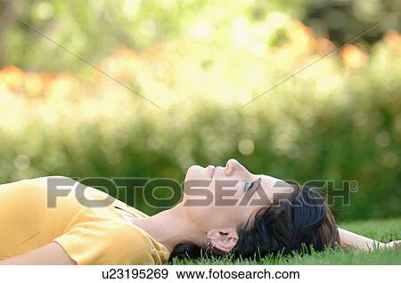 Young woman laying on grass, Regina, Saskatchewan View Large Photo Image Stock Photo - Young woman laying on grass, Regina, Saskatchewan. Fotosearch