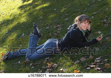 Young woman listening to Ipod outdoors, Brantford, Ontario View Large Photo Image Stock Image - Young woman listening to Ipod outdoors, Brantford, Ontario. Fotosearch
