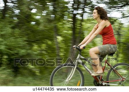 Stock Photography - Young woman riding bicycle, Munson Park, Winnipeg, Canada. Fotosearch