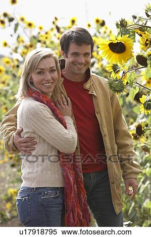 Stock Photography - Couple on an organic farm looking at sunflowers, Ladner, British Columbia, Canada. Fotosearch
