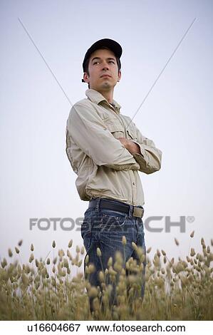 Stock Photo - Low angle portrait of farmer in field of canary seed, Saskatchewan, Canada. Fotosearch