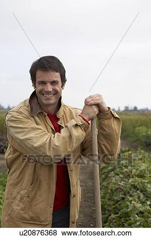 Man holding rake in field of organic vegetables, Ladner, British Columbia, Canada View Large Photo Image Stock Photo - Man holding rake in field of organic vegetables, Ladner, British Columbia, Canada. Fotosearch