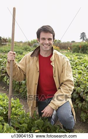 Man kneeling in organic garden, Ladner, British Columbia, Canada View Large Photo Image Stock Image - Man kneeling in organic garden, Ladner, British Columbia, Canada. Fotosearch