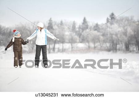 Stock Image - 9 and 13 year-old girls skating on Red River, Winnipeg, Canada. Fotosearch