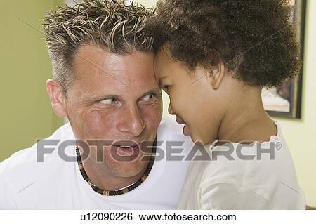 Stock Photograph - Caucasian father and Mulatto girl 3 years old.. Fotosearch