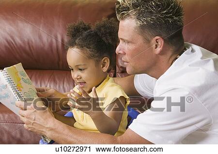 Stock Image - Caucasian father with Mulatto girl (3 years old) at artwork. Fotosearch