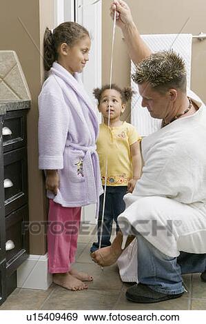Dad measuring the height of his Mulatto girls 3 and 6 years old. View Large Photo Image Stock Photo - Dad measuring the height of his Mulatto girls 3 and 6 years old.. Fotosearch