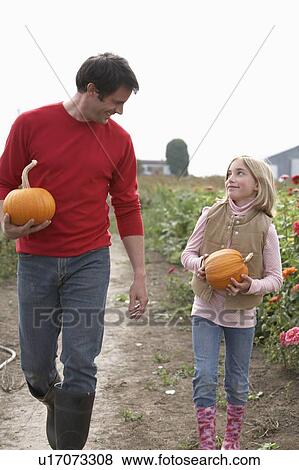 Father and daughter with organic pumpkins walking in farm fields, Ladner, British Columbia View Large Photo Image Stock Photo - Father and daughter with organic pumpkins walking in farm fields, Ladner, British Columbia. Fotosearch