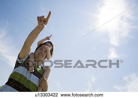 Stock Image - Girl (4) rides on man's shoulders, Grand Beach Provincial Park, Manitoba, Canada. Fotosearch