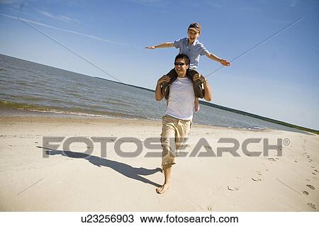Man carries boy (7) on his shoulders as boy holds arms out, Grand Beach Provincial Park, Manitoba, Canada View Large Photo Image Stock Image - Man carries boy (7) on his shoulders as boy holds arms out, Grand Beach Provincial Park, Manitoba, Canada. Fotosearch
