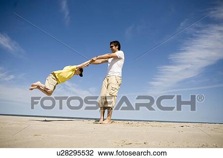 Man swings boy (7) in circle, Grand Beach Provincial Park, Manitoba, Canada View Large Photo Image Stock Image - Man swings boy (7) in circle, Grand Beach Provincial Park, Manitoba, Canada. Fotosearch