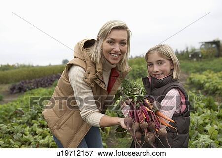 Mother and daughter at an organic farm with fresh vegetables, Ladner, British Columbia, Canada View Large Photo Image Stock Photo - Mother and daughter at an organic farm with fresh vegetables, Ladner, British Columbia, Canada. Fotosearch