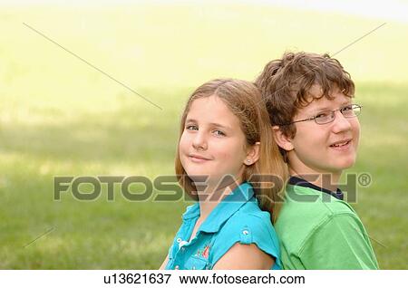 Stock Photo - Portrait of young girl and guy on grass, Regina, Saskatchewan. Fotosearch