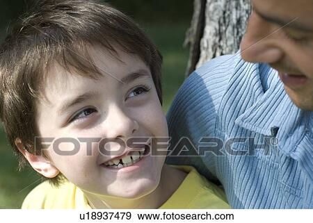 Stock Photo - Six year old boy looks upward to father, Winnipeg, Canada. Fotosearch