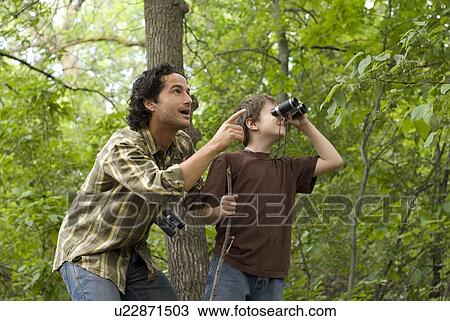 Young boy and father looking through binoculars, Assiniboine Park, Winnipeg, Canada View Large Photo Image Stock Image - Young boy and father looking through binoculars, Assiniboine Park, Winnipeg, Canada. Fotosearch