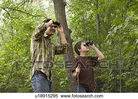 Young boy and father looking through binoculars, Assiniboine Park, Winnipeg, Canada View Large Photo Image Stock Photography - Young boy and father looking through binoculars, Assiniboine Park, Winnipeg, Canada. Fotosearch