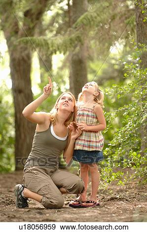Stock Photo - Young woman and child in woods looking at scenery, Regina, Saskatchewan. Fotosearch