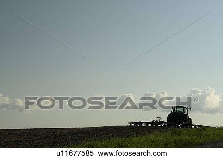 Stock Photography - Tractor with cultivator at the edge of a field; Canada, Manitoba, Erickson. Fotosearch