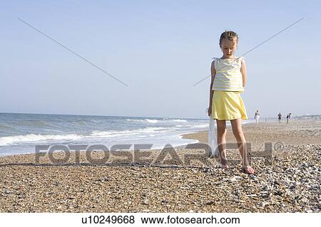 Stock Photo - Girl - (6) looking for the shells on the beach, Jacksonville, Florida. Fotosearch