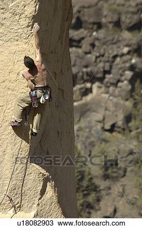 Stock Image - Man (25-30) rock climbing, Smith Rock State Park, Terrebonne, Oregon, USA. Fotosearch