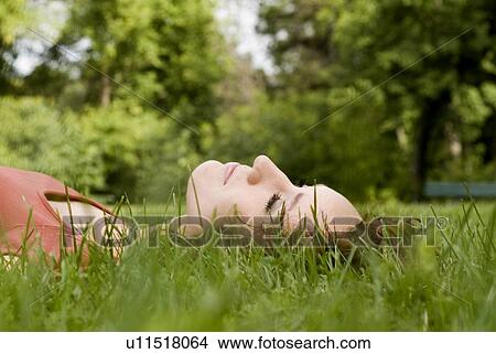 Woman laying on the green grass, Winnipeg, Manitoba, Canada View Large Photo Image Picture - Woman laying on the green grass, Winnipeg, Manitoba, Canada. Fotosearch
